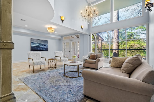 living area featuring baseboards, visible vents, an inviting chandelier, a high ceiling, and french doors