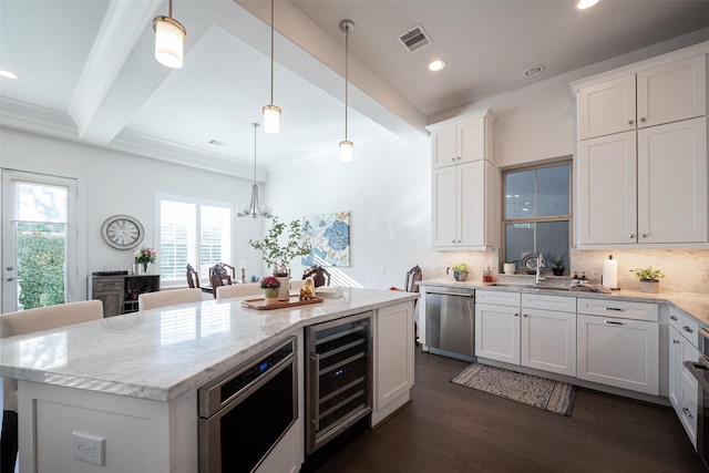 kitchen featuring beverage cooler, dishwasher, a center island, decorative light fixtures, and white cabinetry