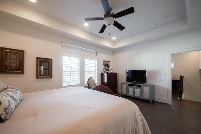 bedroom with recessed lighting, dark wood finished floors, baseboards, a raised ceiling, and crown molding