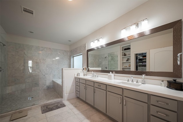 full bath featuring a garden tub, a spacious closet, visible vents, and a sink