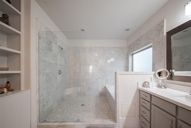 bathroom featuring a garden tub, vanity, and tiled shower