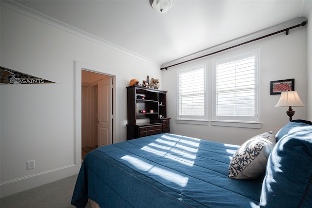 carpeted bedroom featuring baseboards and ornamental molding