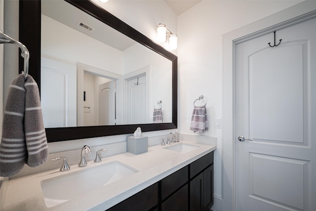 full bath featuring double vanity, a sink, and visible vents