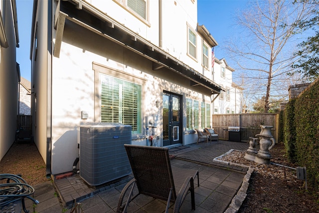 view of patio / terrace with cooling unit, a fenced backyard, and a grill