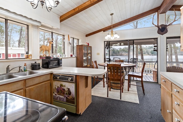 kitchen featuring vaulted ceiling with beams, light countertops, an inviting chandelier, a sink, and black microwave