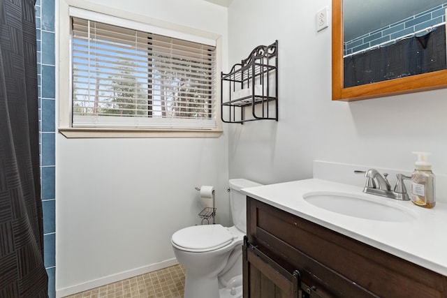 bathroom featuring toilet, curtained shower, vanity, and baseboards