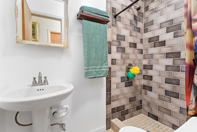 bathroom with a stall shower and a sink