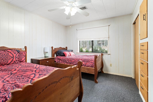 bedroom with ceiling fan, visible vents, baseboards, ornamental molding, and dark carpet