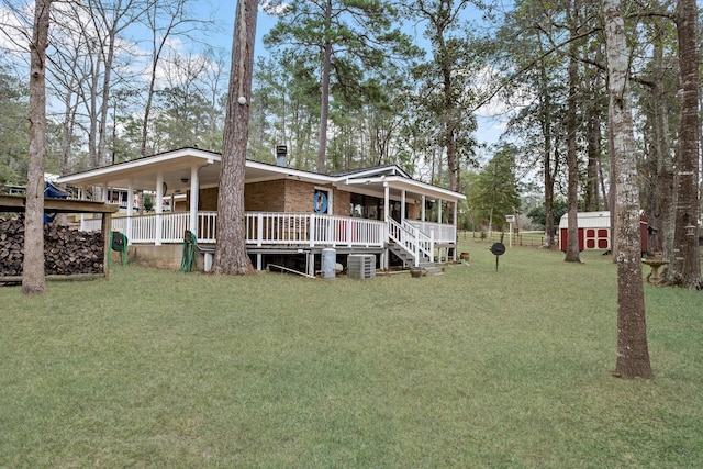 view of front of home with a shed, a front yard, a porch, and an outdoor structure