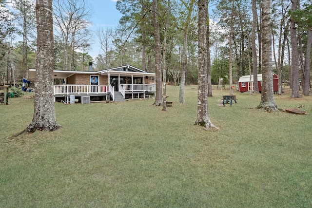 view of yard with covered porch, a shed, and an outdoor structure