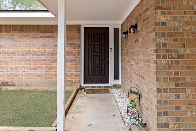 view of exterior entry featuring brick siding