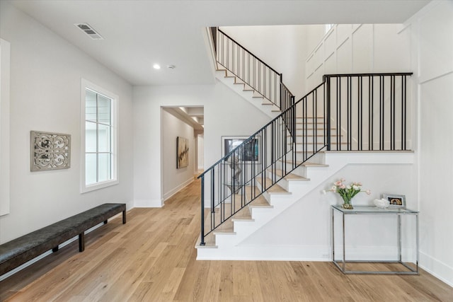 staircase featuring recessed lighting, visible vents, baseboards, and wood finished floors