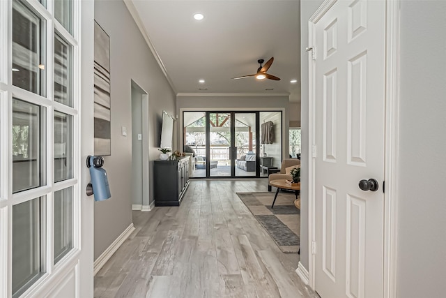 corridor featuring ornamental molding, light wood-type flooring, baseboards, and recessed lighting