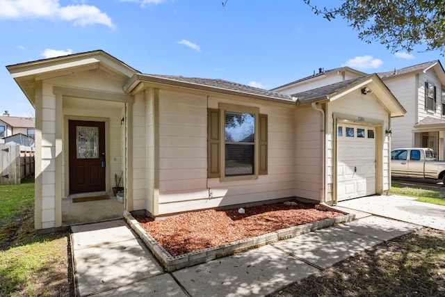 single story home with a garage, driveway, and fence