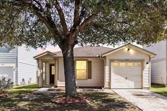 ranch-style house featuring an attached garage, a shingled roof, and concrete driveway