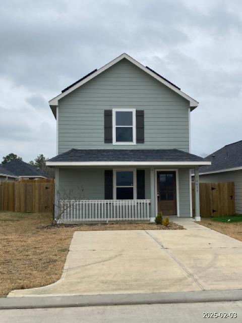 traditional home featuring covered porch and fence