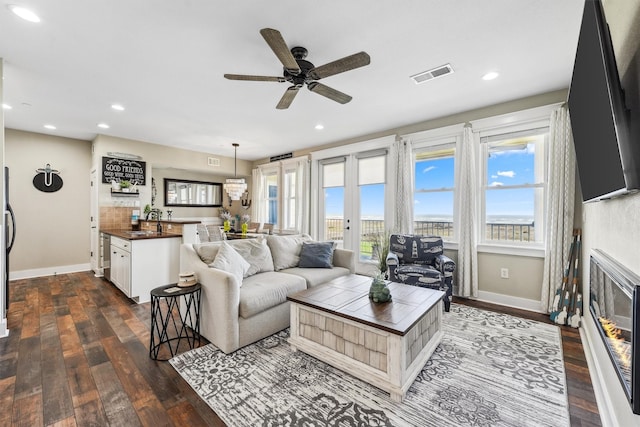 living area featuring recessed lighting, visible vents, baseboards, and dark wood finished floors