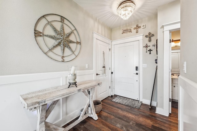 entryway with a chandelier and dark wood-style flooring