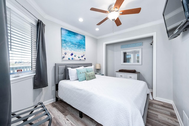 bedroom with crown molding, baseboards, and wood finished floors