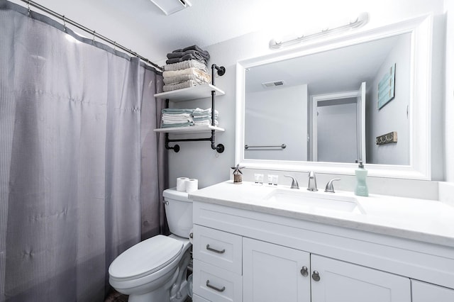 bathroom featuring toilet, vanity, and visible vents