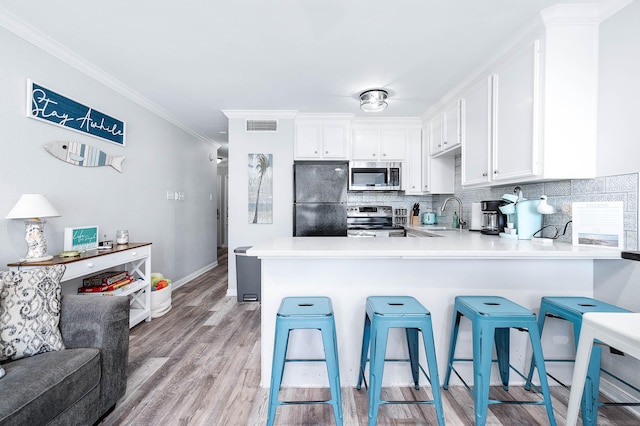 kitchen featuring appliances with stainless steel finishes, visible vents, crown molding, and backsplash