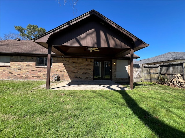 rear view of house featuring a lawn, a patio area, fence, and a ceiling fan