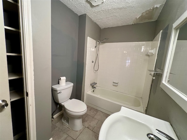 full bath with a textured ceiling,  shower combination, a sink, and toilet