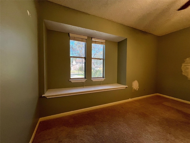 carpeted empty room with a textured ceiling and baseboards