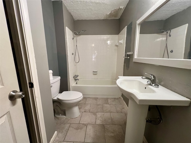 bathroom with a textured ceiling, shower / bathtub combination, and toilet