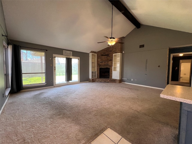 unfurnished living room featuring beam ceiling, carpet flooring, a fireplace, and ceiling fan