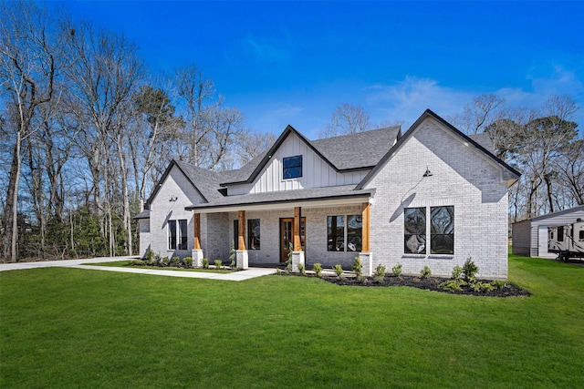 view of front facade with board and batten siding, brick siding, a porch, and a front lawn