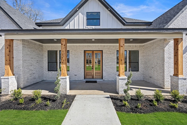 doorway to property with a porch, board and batten siding, and brick siding