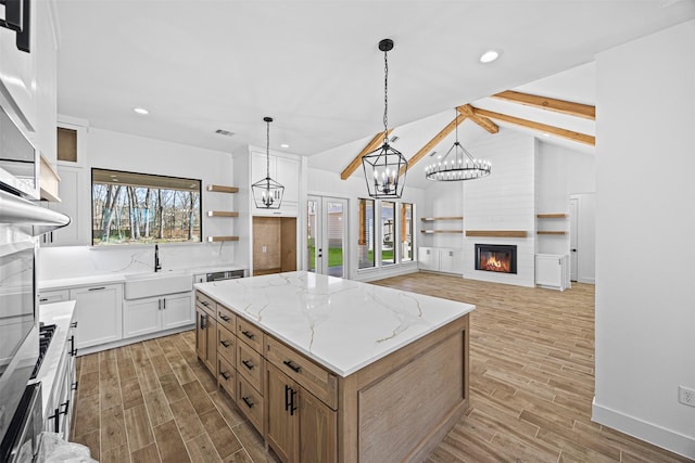 kitchen featuring brown cabinets, decorative light fixtures, open shelves, white cabinetry, and a kitchen island