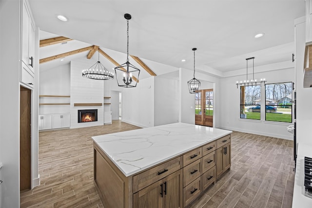 kitchen with open floor plan, brown cabinetry, white cabinetry, and pendant lighting