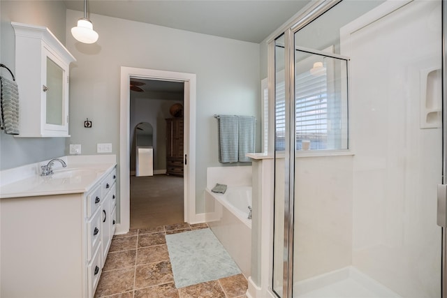 bathroom featuring a shower stall, vanity, and a bath