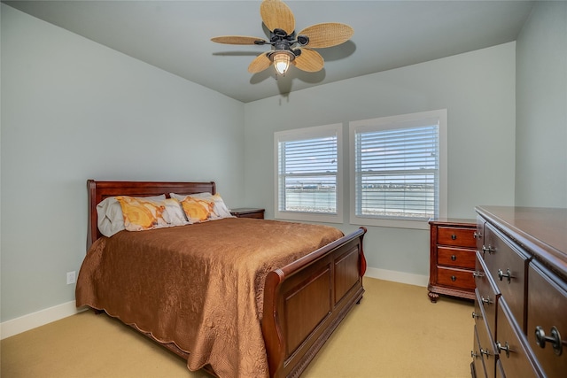 bedroom with ceiling fan, baseboards, and light colored carpet