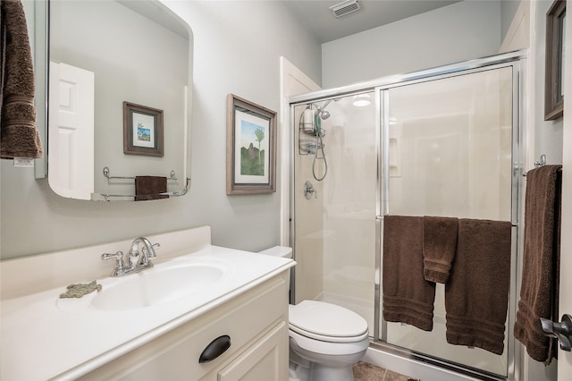 bathroom featuring toilet, a stall shower, vanity, and visible vents