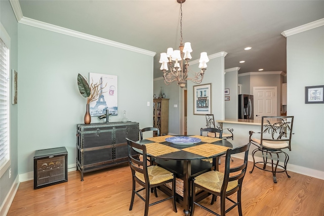 dining room with ornamental molding, light wood-type flooring, and baseboards