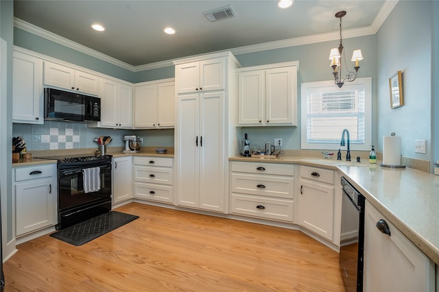 kitchen featuring a sink, white cabinetry, light wood-style floors, black appliances, and crown molding