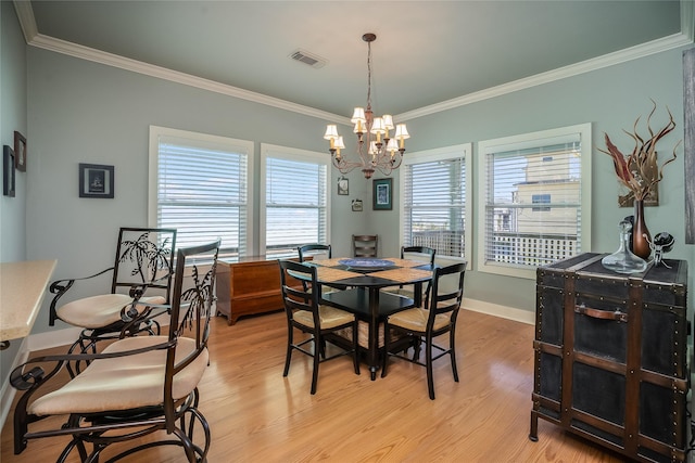 dining room featuring light wood-style flooring, visible vents, baseboards, and ornamental molding