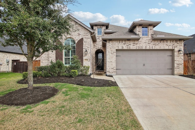 french country inspired facade featuring a garage, driveway, fence, a front lawn, and brick siding