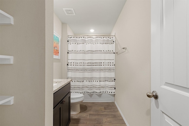 bathroom with visible vents, toilet, shower / bath combo, vanity, and wood finished floors