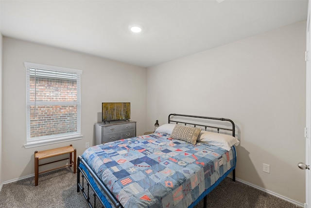 bedroom featuring baseboards and dark carpet