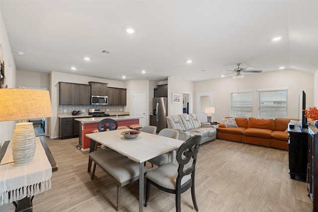 dining room featuring light wood-type flooring, visible vents, vaulted ceiling, and recessed lighting