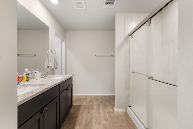 full bath with visible vents, a sink, and wood finished floors