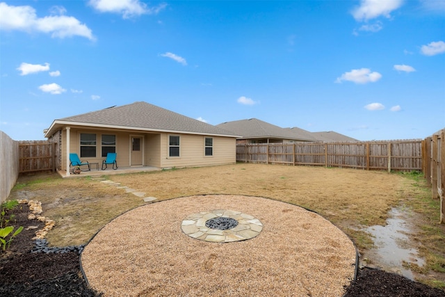 back of property featuring a shingled roof, a fenced backyard, and a patio