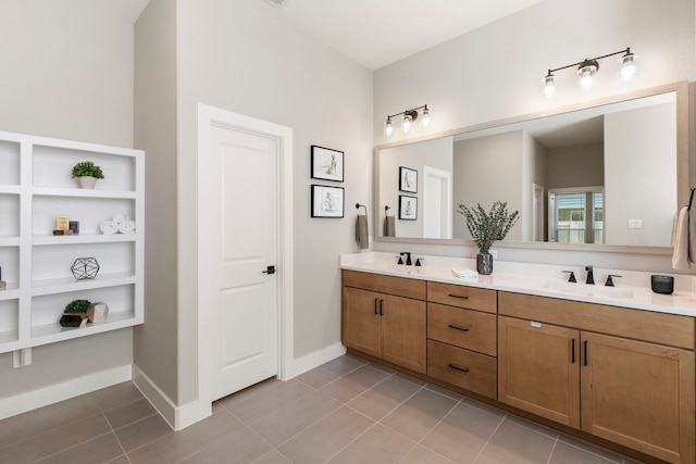 bathroom featuring baseboards, double vanity, a sink, and tile patterned floors