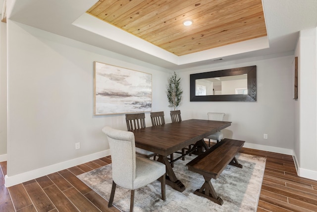 dining space with wooden ceiling, baseboards, dark wood-style floors, and a tray ceiling