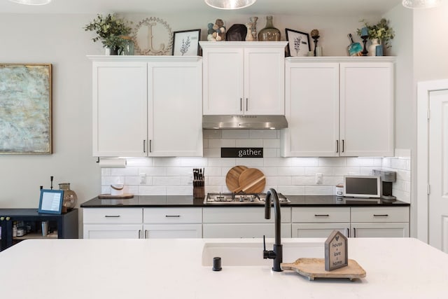 kitchen with white cabinetry, stainless steel gas stovetop, and under cabinet range hood