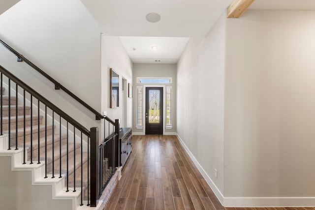 foyer with stairs, baseboards, and wood finished floors